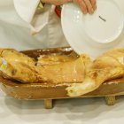 Tradicional ritual de partir el cochinillo con un plato