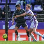 El delantero Latasa agarra al defensa Alberto para que no juegue el balón.