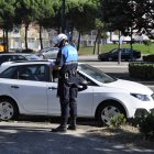 Dos policías multan a un coche parado en una calle de Valladolid.