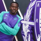 Sani Buhari, junto al escudo del club.