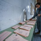 Una persona elige papeleta en un colegio electoral.