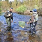Dos aficionados con una buena trucha en la Tabla de Los Antolines del río Carrión palentino.