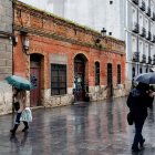Varios viandantes se protegen de la lluvia en el centro de Valladolid