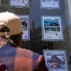 Una persona observa los anuncios en el escaparate de una inmobiliaria.