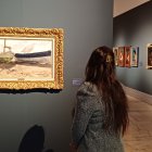 Una mujer contempla el óleo de 1900 ‘Barcas en la playa’, de Joaquín Sorolla.