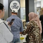 Dos personas tramitan su número para acceder al servicio de Correos.