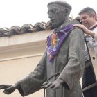 Un operario coloca el pañuelo festivo a la estatua de San Pedro Regalado en Valladolid, símbolo de la celebración de su festividad cada 13 de mayo
