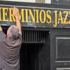 Roberto, uno de los dueños de Herminio's Jazz, colgando el letrero en el local cerrado.