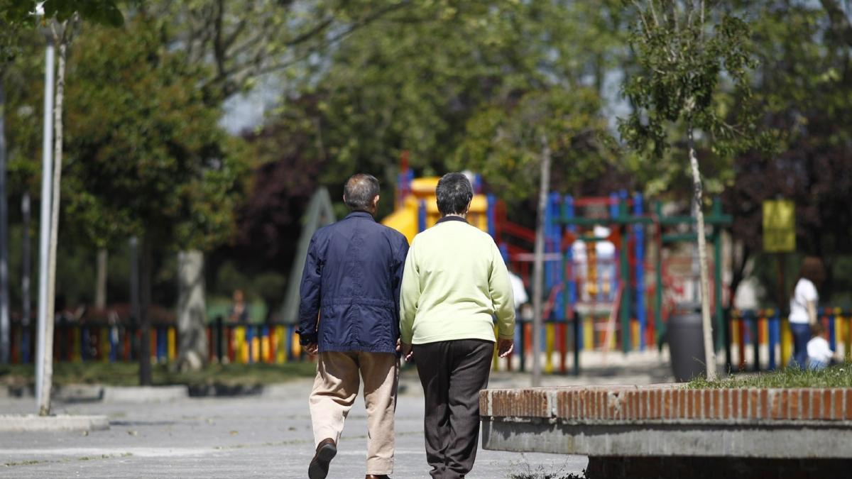 Dos ancianos pasean por el parque.