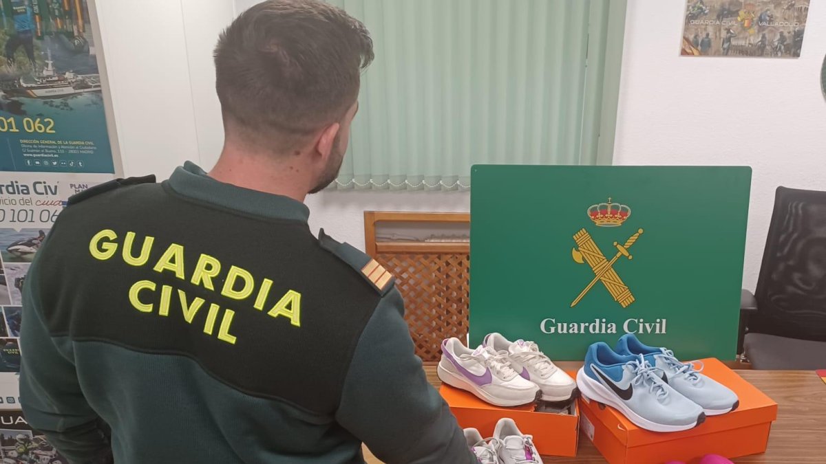 Agente de la Guardia Civil junto con el botín arrebatado a una mujer acusada de robo con fuerza.
