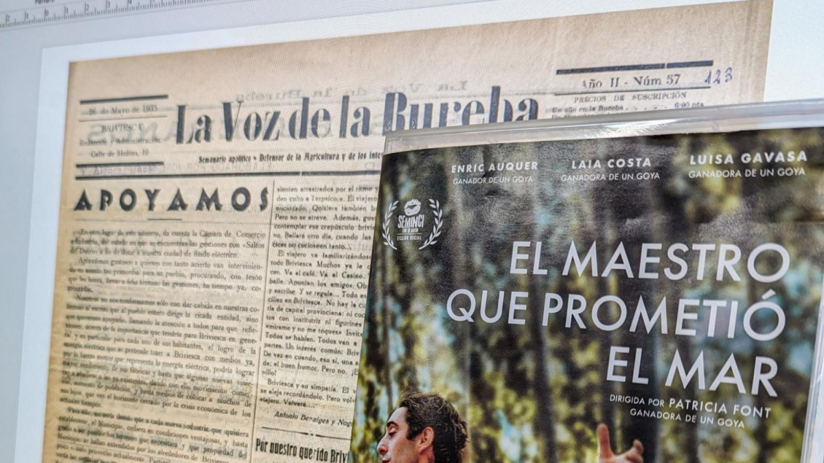 Un ordenador de la Biblioteca de Castilla y León muestra un ejemplar del periódico 'La Voz de la Bureba' ante el cartel de la película 'El maestro que prometió el mar', sobre la figura de Antonio Benaiges.