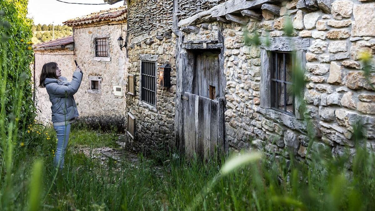 Una joven fotografía una casa de La Cuenca.