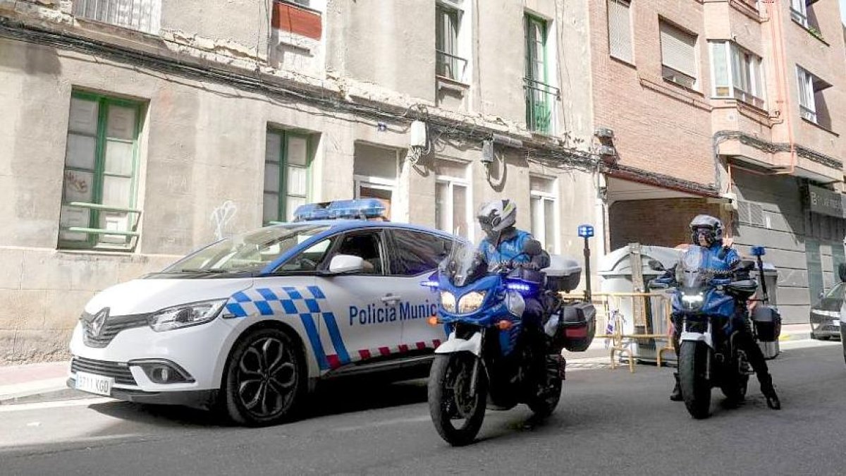 Patrulla de la Policía Municipal en la entrada del edificio okupado en el momento en que llegan dos efectivos de la Policía Nacional. J. M. LOSTAU