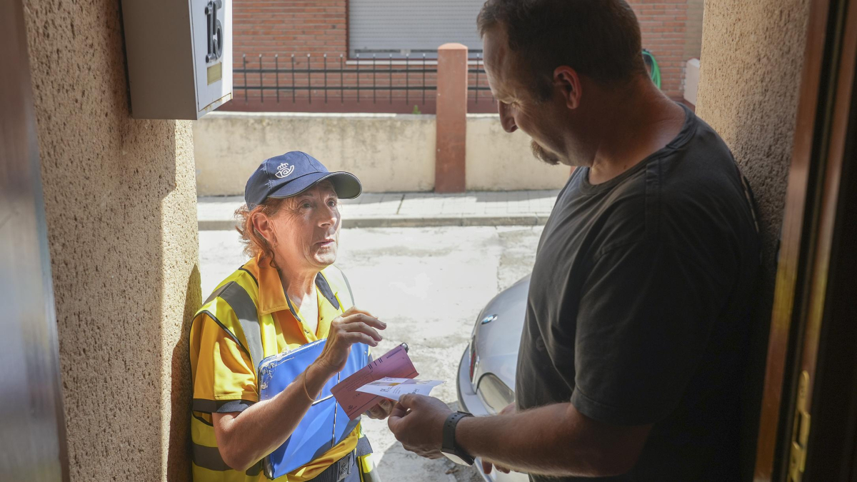 Esmeralda García entrega una carta a un vecino de la localidad vallisoletana de Alcazarén