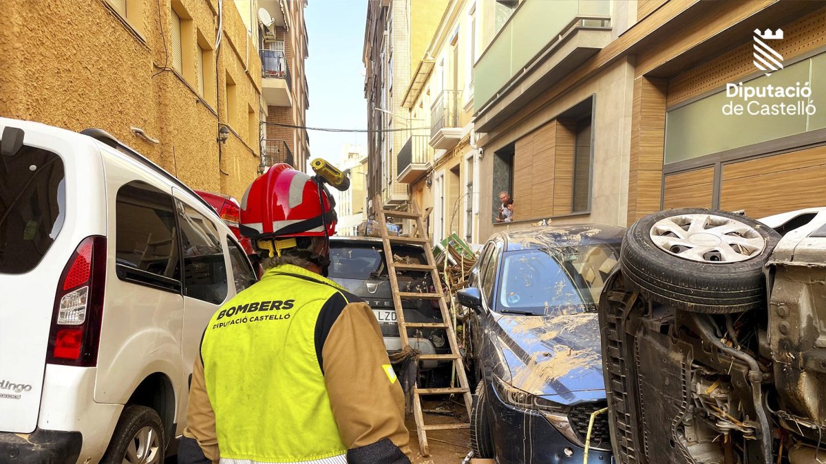 Un bombero ante los coches arrastrados y amontonados por la Dana.
