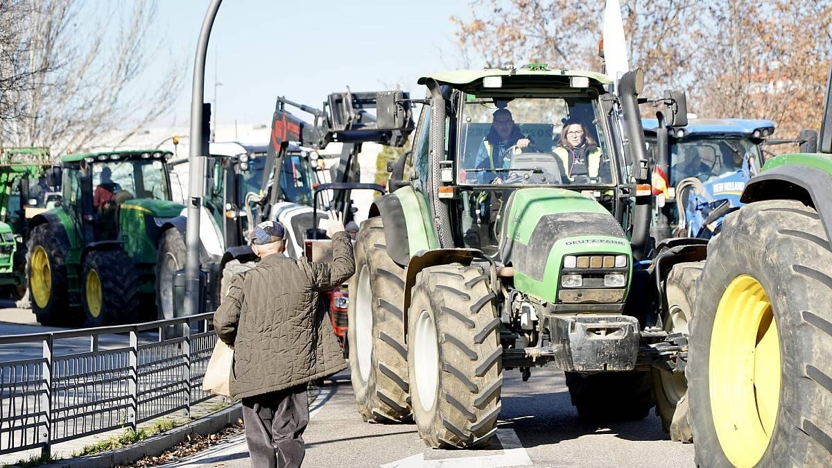 Un transeúnte muestra su apoyo a los agricultores y saluda a la conductora de un tractor que participa en la comitiva. ICAL