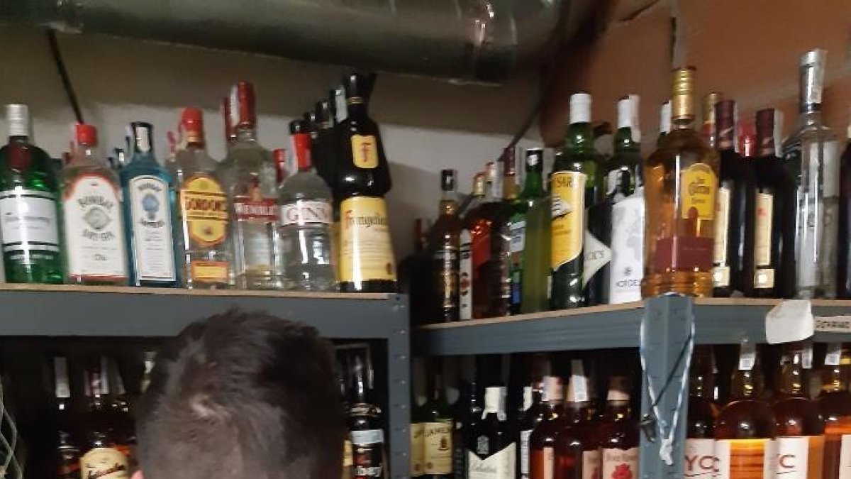 Un agente de la Guardia Civil frente a varias botellas de alcohol