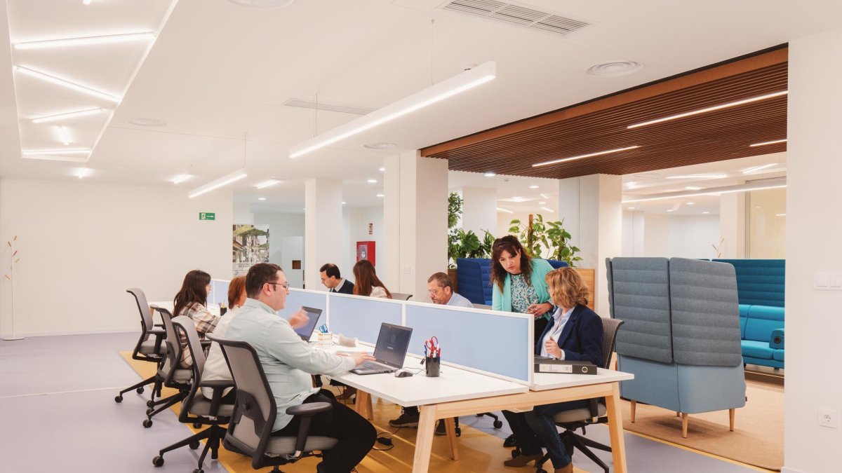 Varias personas alrededor de una mesa con sus portátiles.