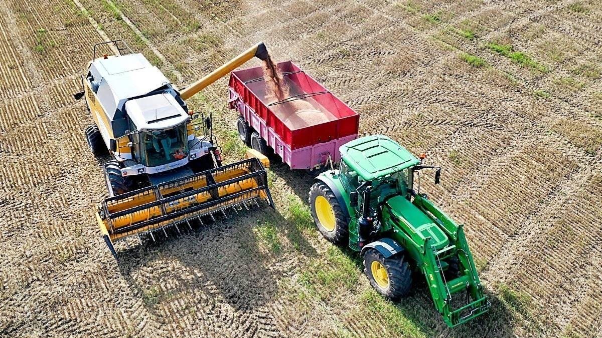 Una cosechadora deposita el grano en un remolque sobre un campo de cereal recién cortado. PXB / CCO