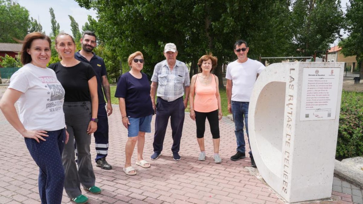 Eva, Silvia, Sergio, Espe, Tomás, Juani y el Alcalde Diego posan junto a la D que indica las rutas de Delibes en Villavaquerín.