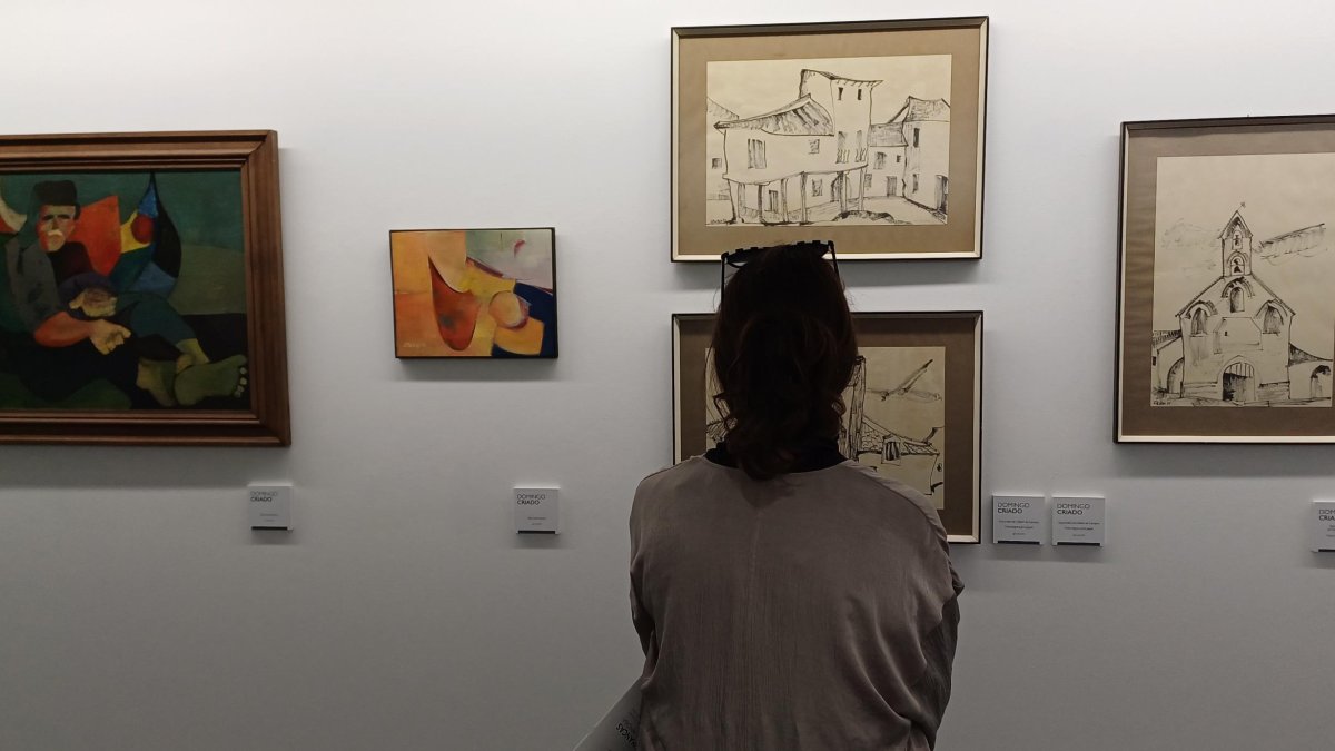 Una mujer contempla algunas obras de la exposición