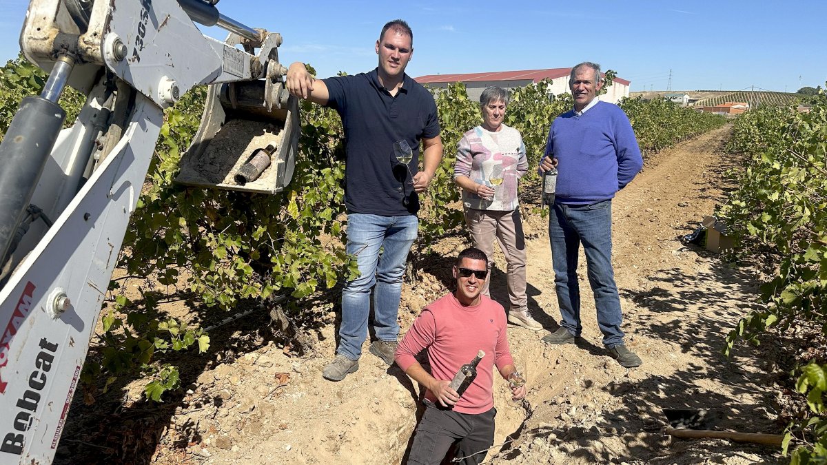 Marga Vidal y Miguel Ángel Vidal con sus hijos Daniel y Sergio en la zanja donde se crió bajo tierra el vino de la uva de la propia viña.