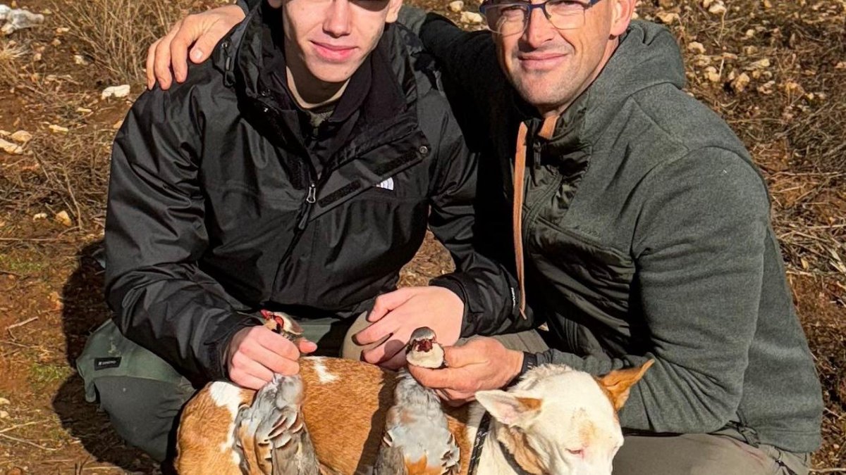 Dos cazadores, padre e hijo, con su cupo de una perdiz en un coto salmantino.