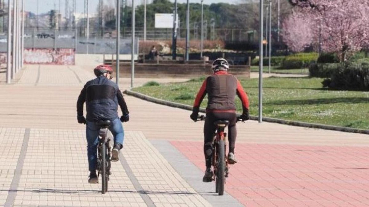 Dos hombres recorriendo la ciudad en bicicleta y disfrutando del buen tiempo
