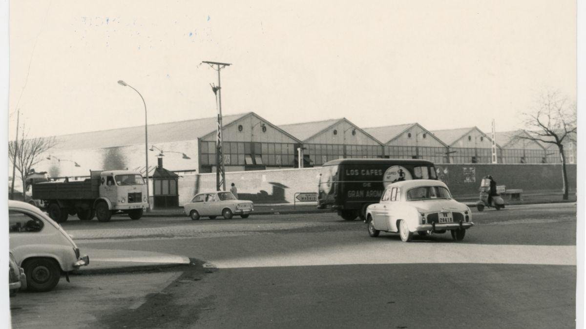 Vehículos circulando en el cruce del paseo de San Vicente con la avenida de Segovia, con los talleres de Renfe al fondo en los 70.