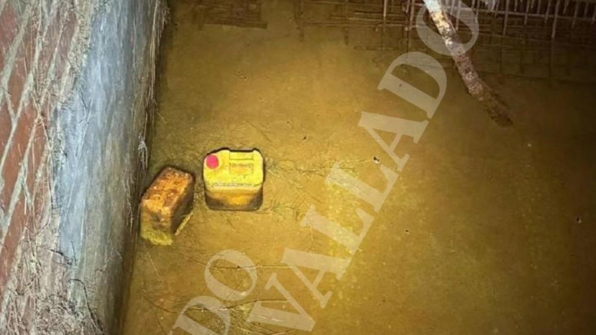 Interior del zulo, donde se observa la ferralla, el agua, unos palos y garrafas de plástico.