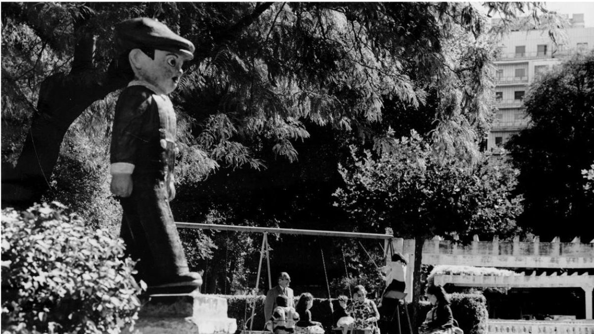 Niños jugando en un columpio en el parque de la plaza del Poniente en los años 70