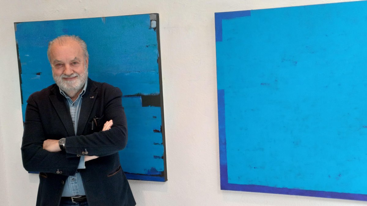 Mariano Olcese junto a dos de sus obras en La Maleta.