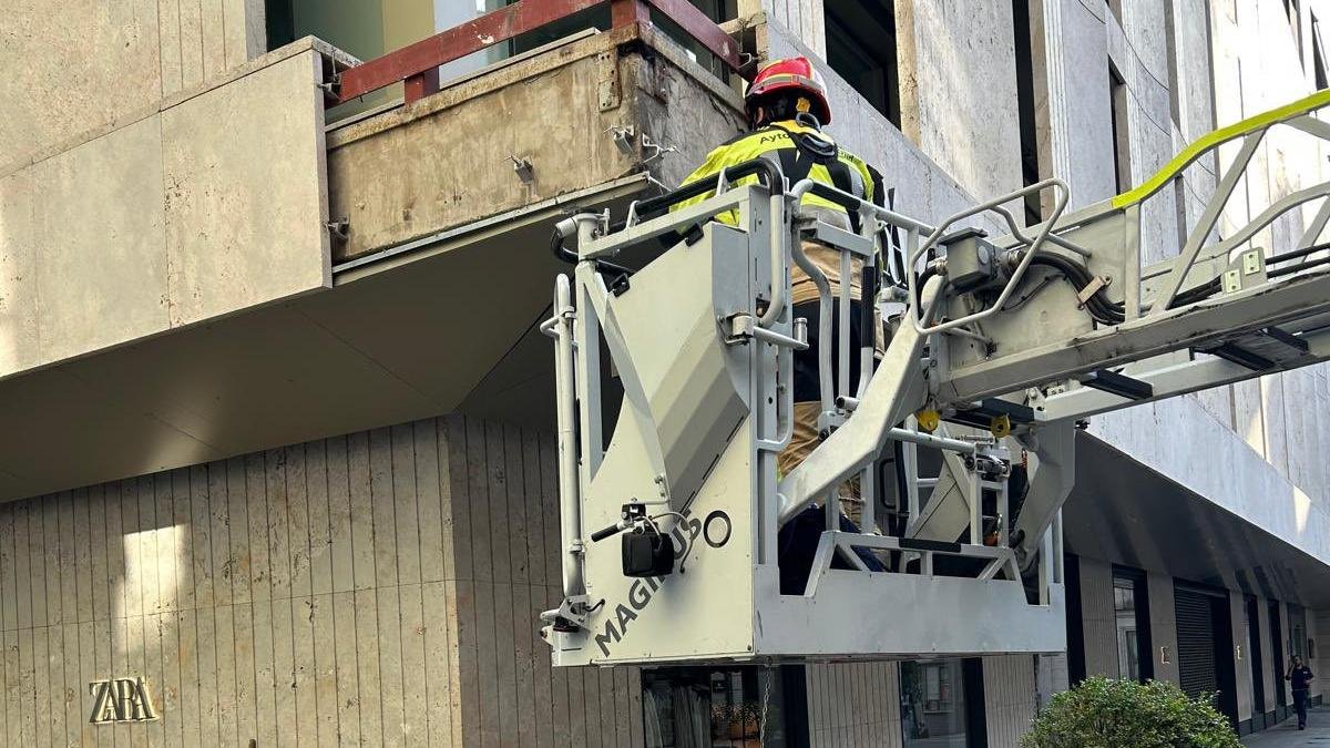 Labores de saneamiento por parte de los Bomberos de Valladolid en la fachada del Zara de la calle Constitución.