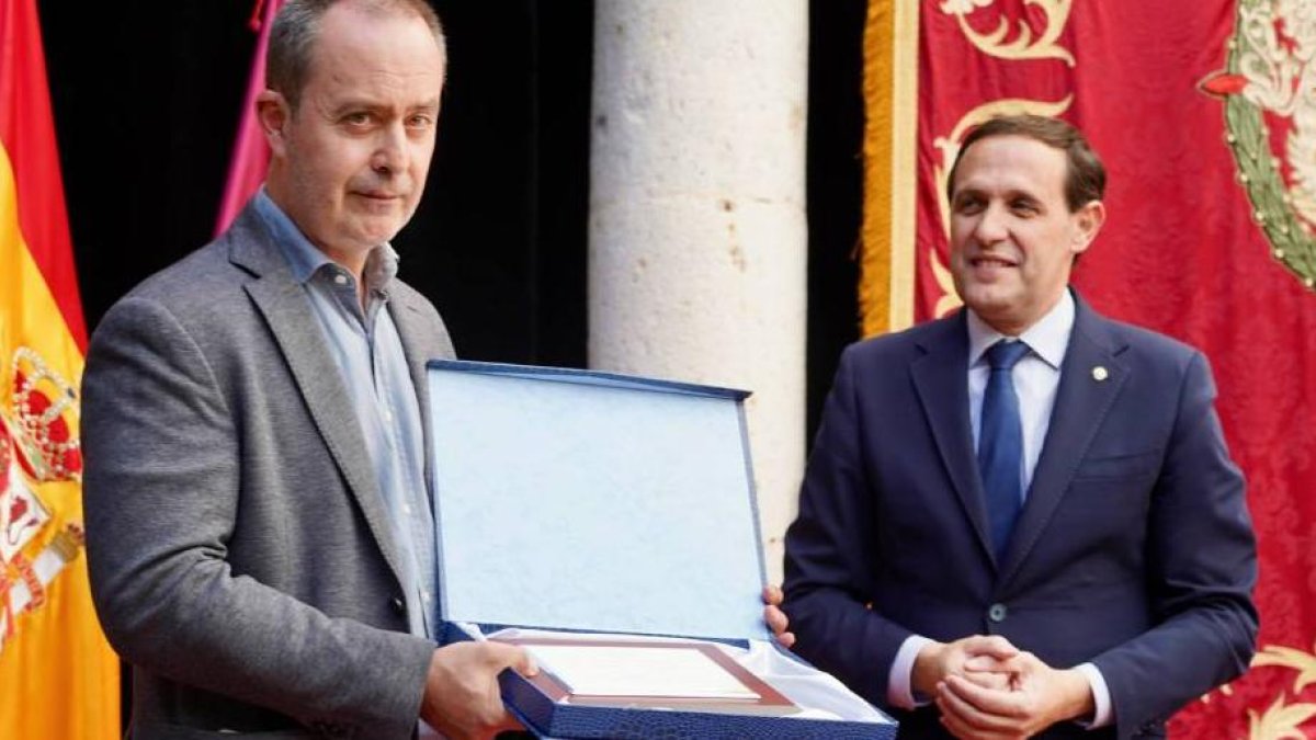 El periodista de El Mundo de Valladolid Julio Tovar recibe el premio de manos de Conrado Íscar.
