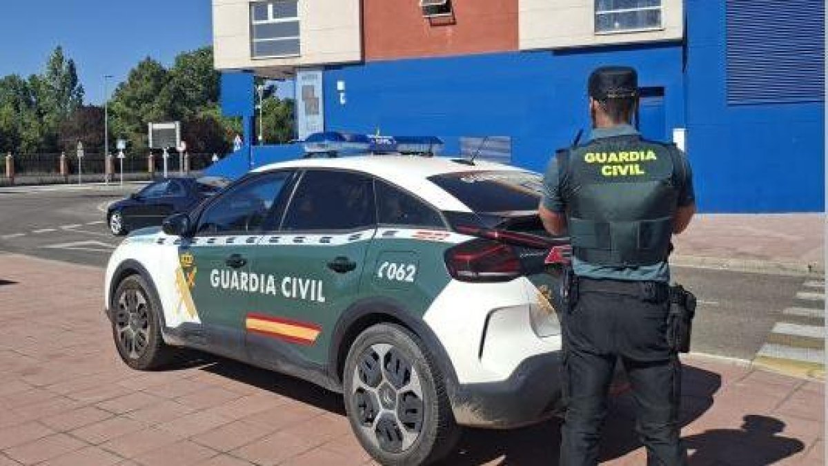 Imagen de un vehículo y un agente de la Guardia Civil