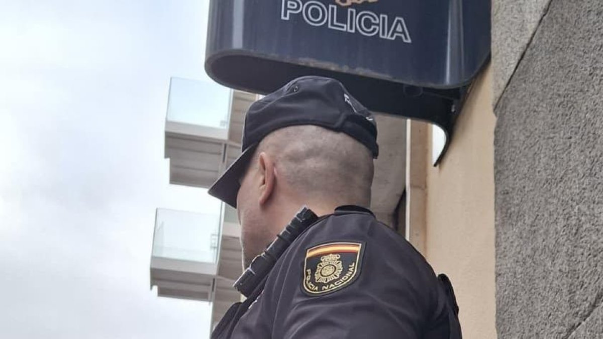 Un agente frente a una comisaría de la Policia Nacional.