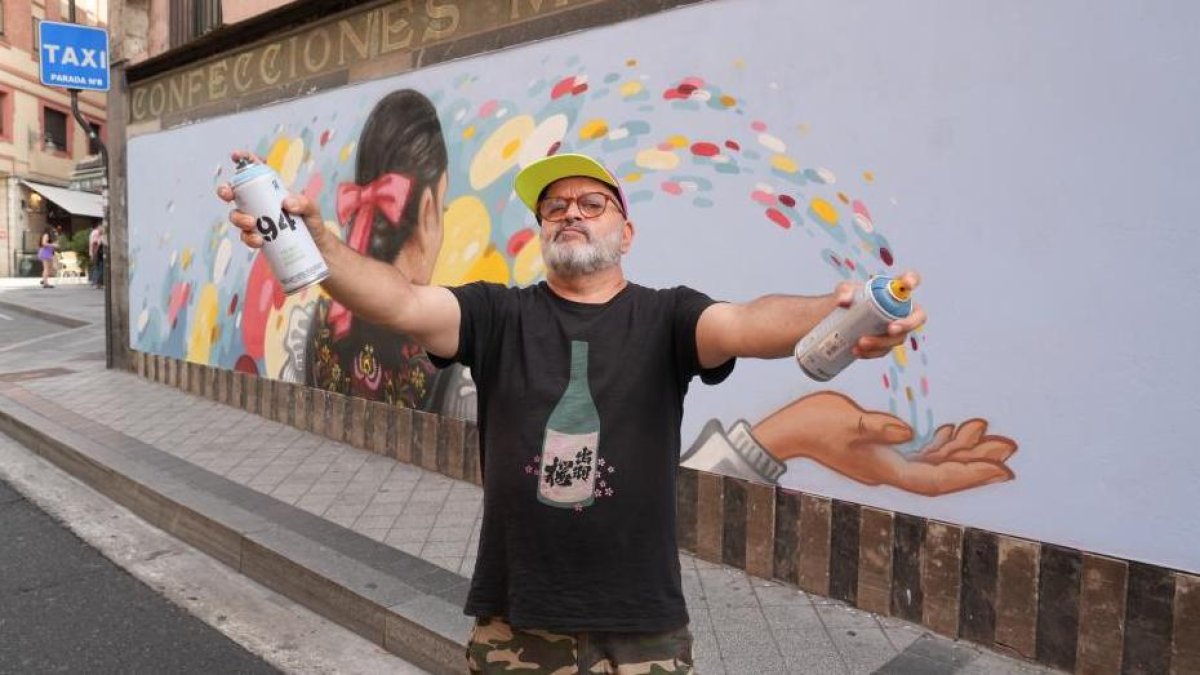 El grafitero ‘Zeta’ con el mural pintado en la plaza del Corrillo
