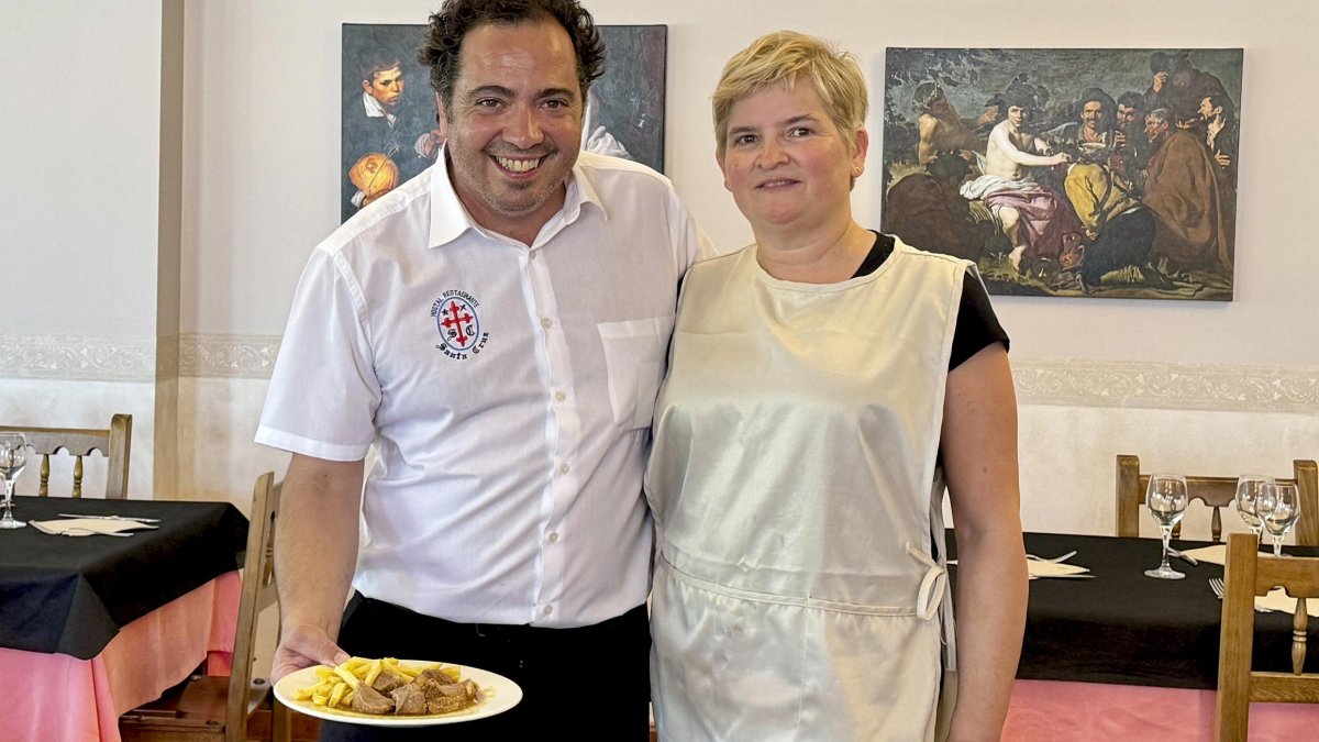 Francisco y Ana María, en el comedor del restaurante Santa Cruz, con las réplicas de los cuadros a su espalda.