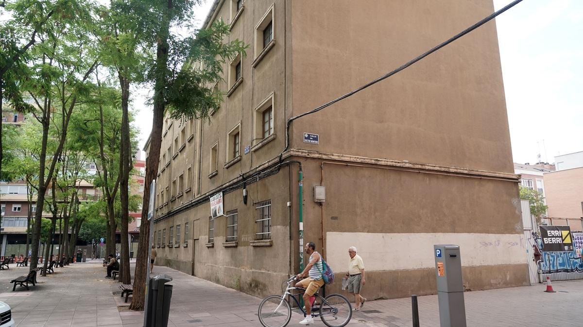 Dos personas pasan por delante del viejo cuartel de Vadillos, donde ya han comenzado las demoliciones.