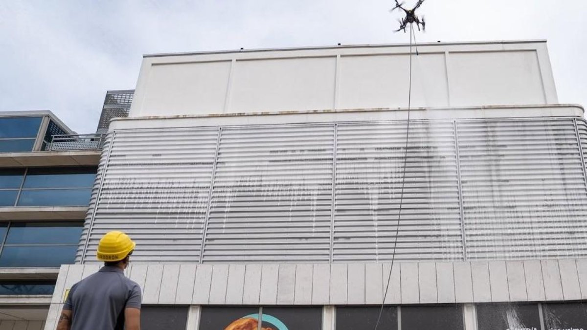 Un operario maneja un dron para limpiar la fachada del centro comercial Vallsur.