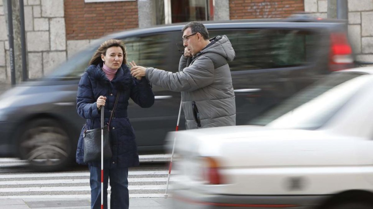Patricia y Claudio cruzando la calle, con su bastón rojo y blanco.-J. M. LOSTAU