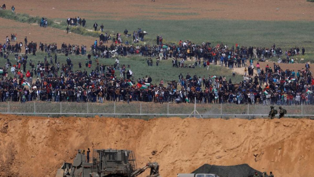 Cientos de palestinos protestan en Gaza frente a la frontera con Israel, este viernes.-REUTERS
