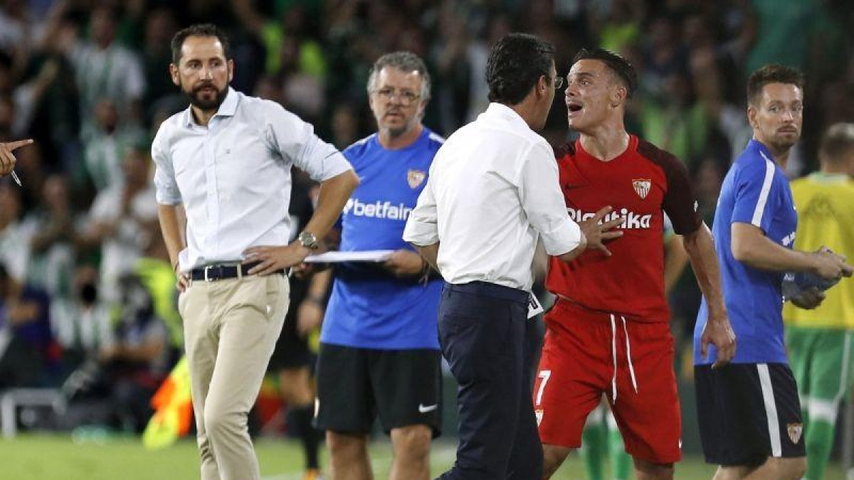 El jugador del Sevilla Roque Mesa (de rojo) protesta tras ser expulsado ante el Betis.-JOSE MANUEL VIDAL (EFE)
