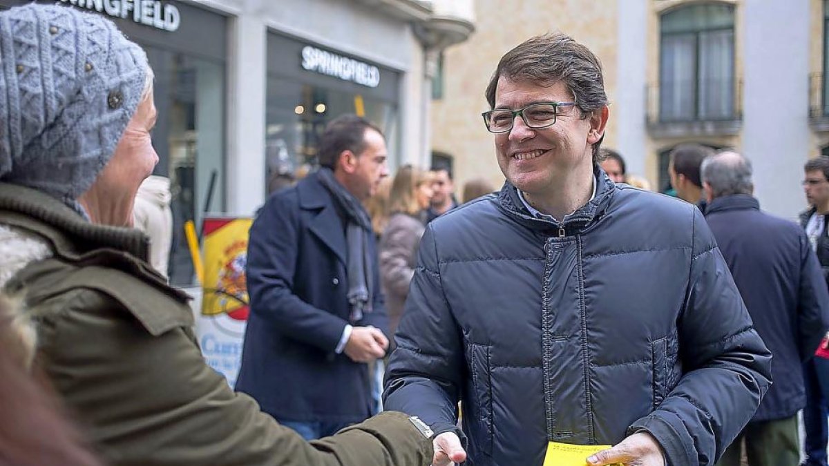 El secretario regional del PP, Alfonso Fernandez Mañueco, entrega ejemplares de la Constitución en Salamanca.-ICAL