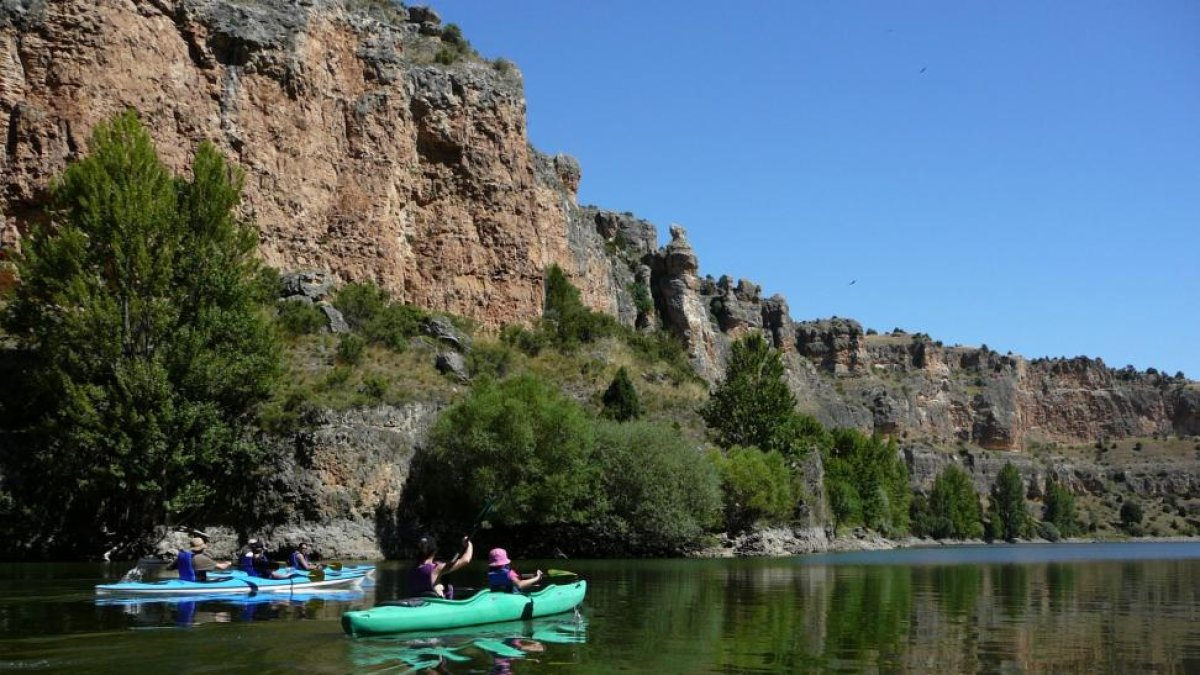 Excursionistas realizan una ruta en canoa por el cañón del río Lobos. A la derecha, panorámica de las Arribes del Duero.-FUNDACIÓN PATRIMONIO NATURAL