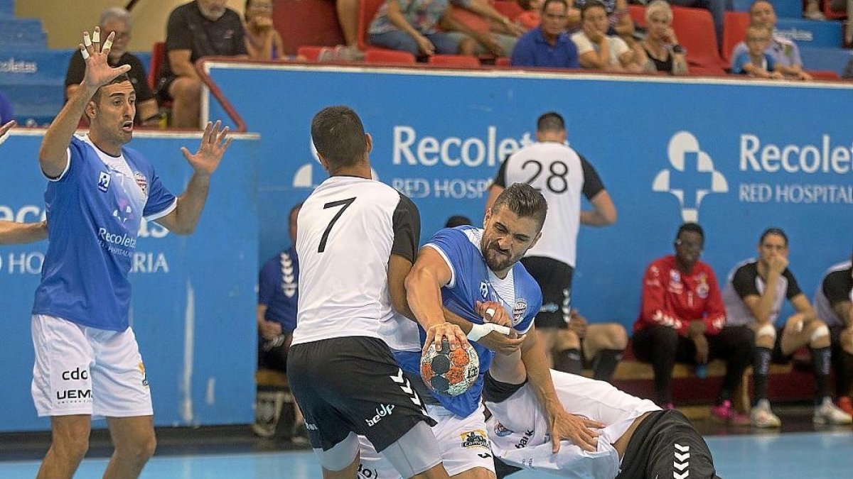 Roberto Pérez intenta zafarse de la férrea defensa cántabra en el duelo jugado en Huerta del Rey en pretemporada.-J. C. CASTILLO