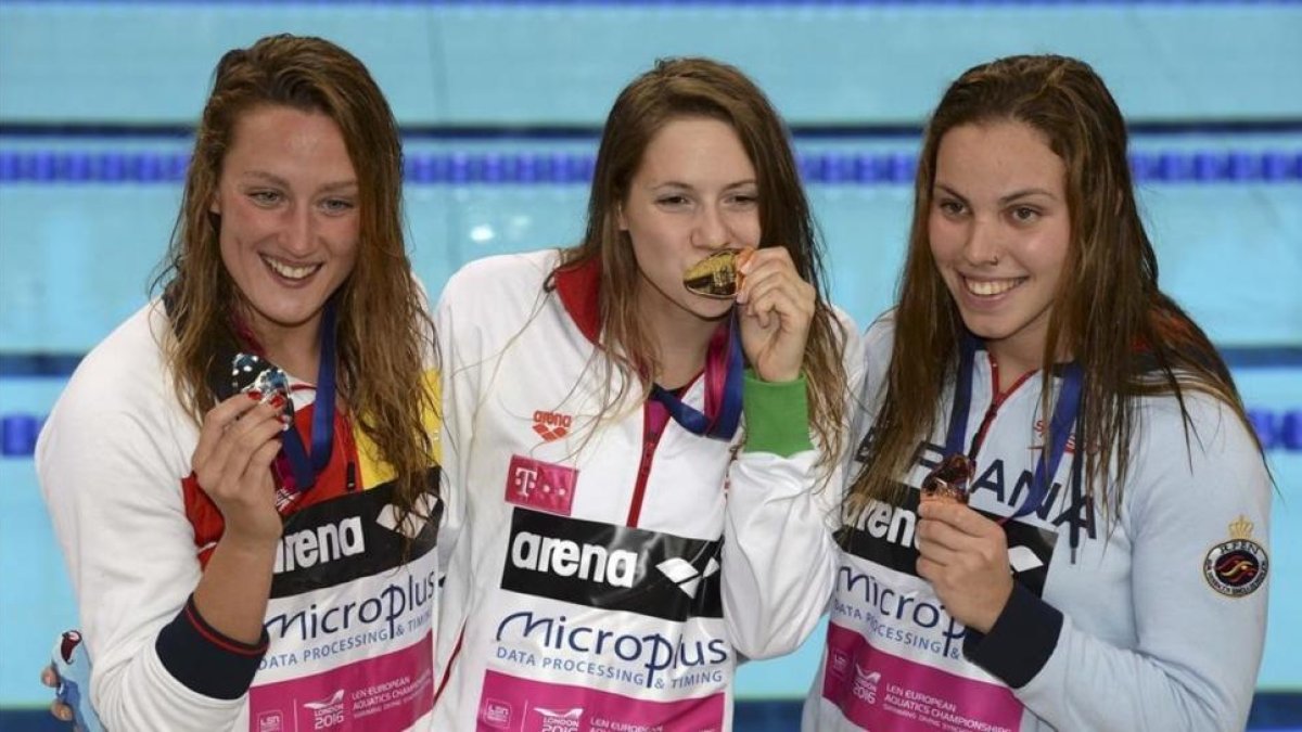 Mireia Belmonte (izquierda, plata) y María Vilas (derecha, bonce) flanquean a la húngara Boglarka Kapas tras recibir sus respectivas medallas en la prueba de los 1.500 metros libre en los Campeonatos de Europa de Natación de Londres.-REUTERS / TONY O'BRIEN