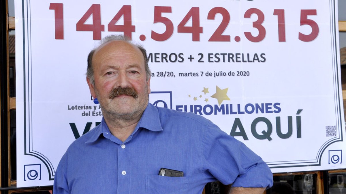 Ángel Iluminado posa en su bar de Mayorga junto al número premiado en aquel Euromillones de julio de 2020. / SGC