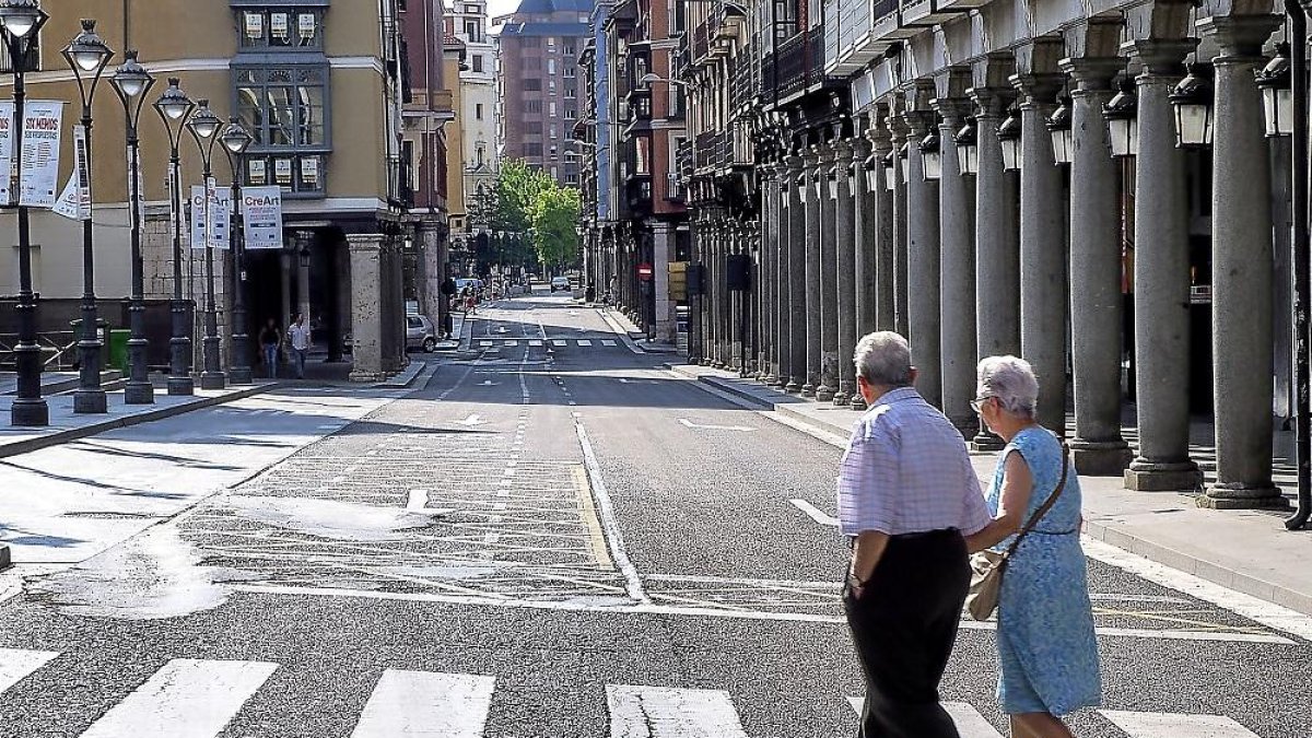 Dos ancianos cruzan una céntrica calle sin coches en la calzada. - E.M.