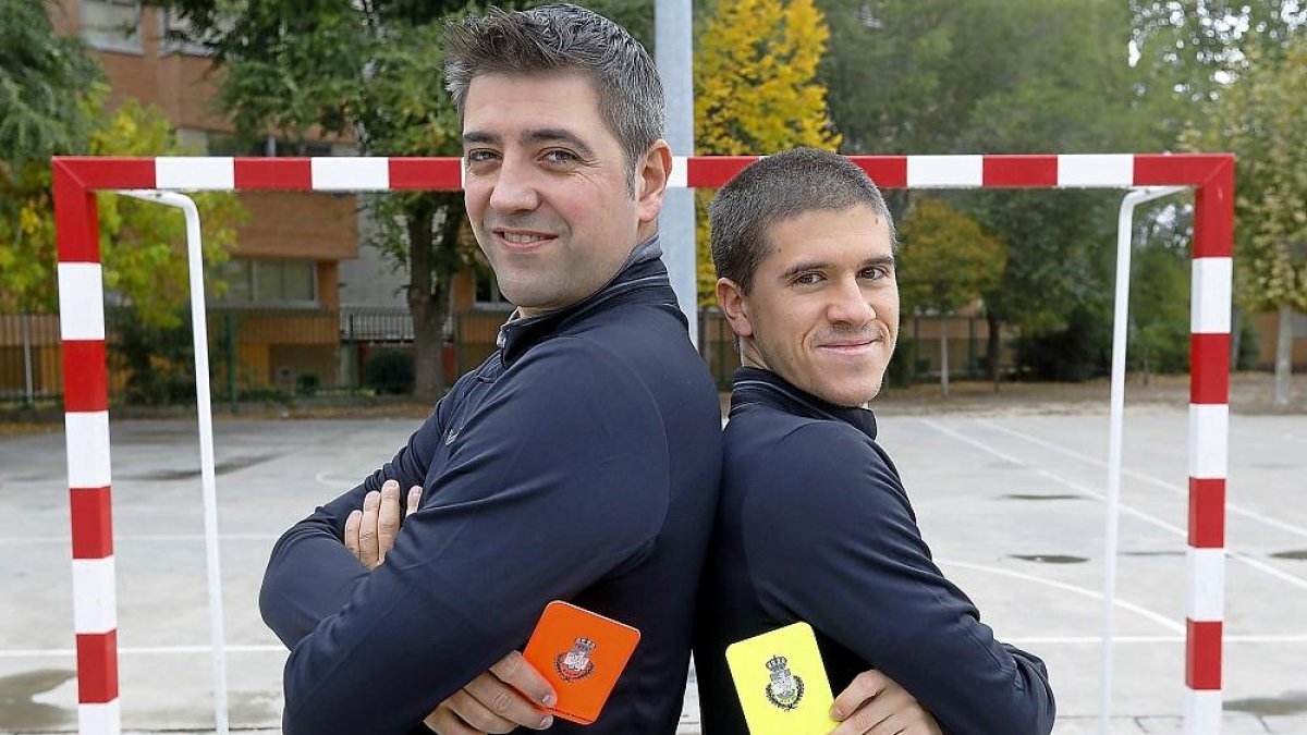 Los árbitros de Asobal Luis Colmenero y Víctor Rollán posan con sus tarjetas en el patio del colegio.-J. M. LOSTAU